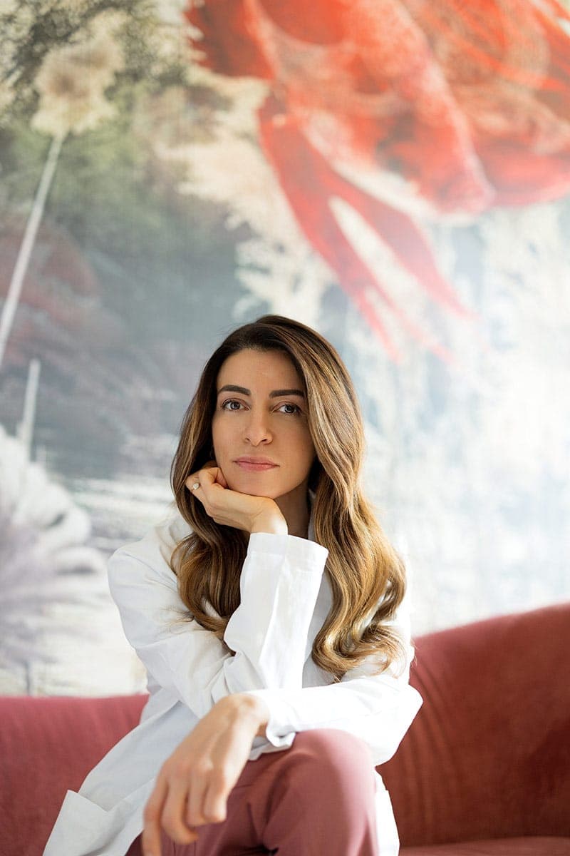 Professionista di estetica medica in uniforme rosa allo studio, ambiente moderno e accogliente.